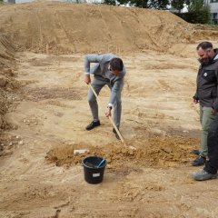 Bürgermeister bedeckt Zeitkapsel mit Erde