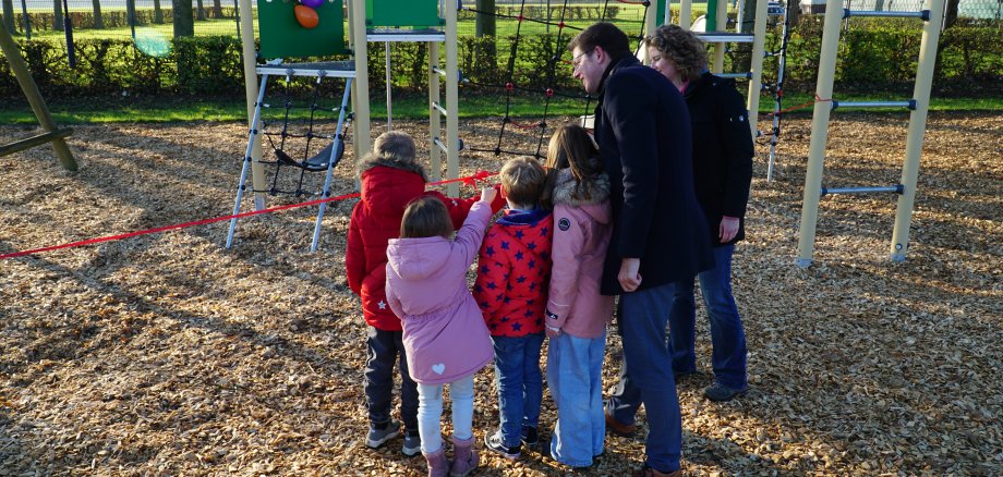 Kinder und Bürgermeister schneiden rotes Band durch