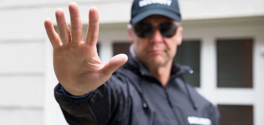 Security Guard Making Stop Gesture Outside Building